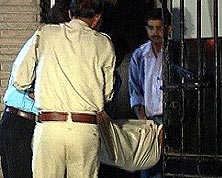 Policemen carry Priya's body from her residence.