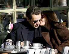 Carla Sarkozy kisses Nicolas Sarkozy at a cafe terrace