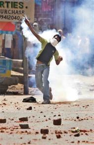 Gujjar, a lower caste, returns a police teargas shell in Aya Nagar area during a stir threatening to shut down the capital, in New Delhi, India, Thursday, May 29, 2008. Gujjars blocked major roads and burned car tires outside New Delhi on Thursday as they marched in the wake of violent protests in the country's north and west that left 39 people dead, 38 shot by police.