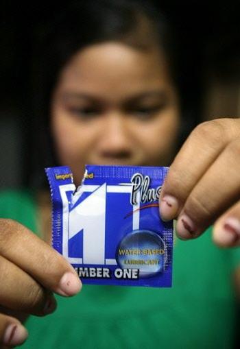 A Cambodian woman holds a wrapper from Number One Plus condom