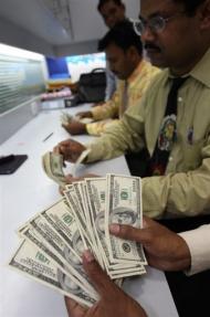 Employees of an exchange bureau count US dollar currency notes