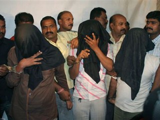 Police personnel show three of the five people allegedly involved in serial blasts in various parts